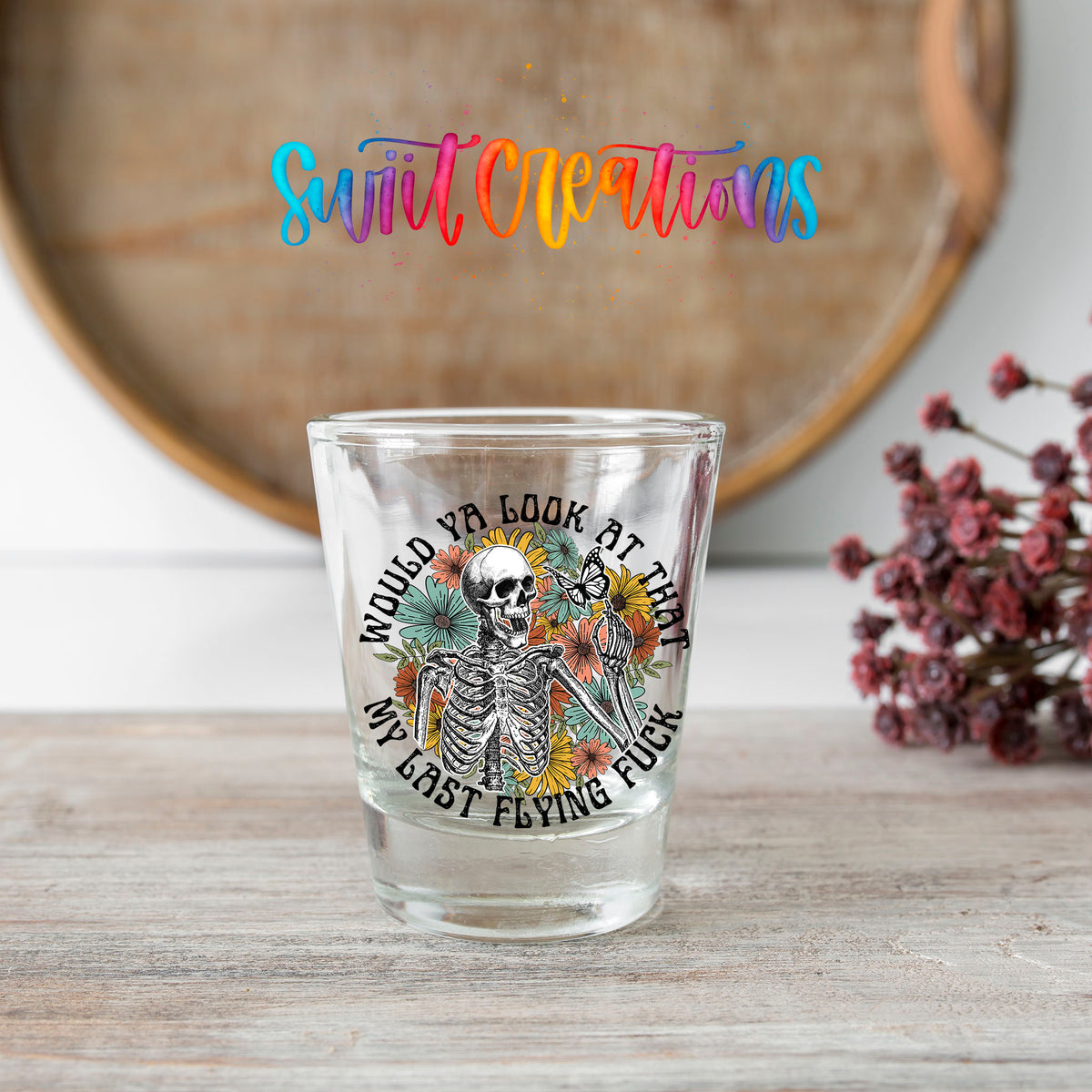 Would You Look At That My Last Flying F*ck shot glass transfer on a clear glass beside a wooden barrel and dried flowers