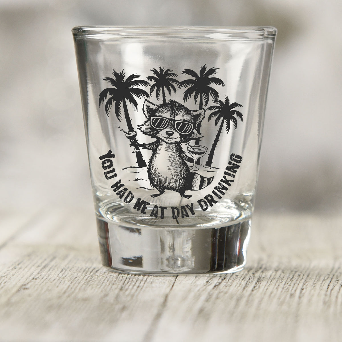 You Had Me at Day Drinking shot glass UV DTF transfer with raccoon in sunglasses with palm trees on a clear shot glass