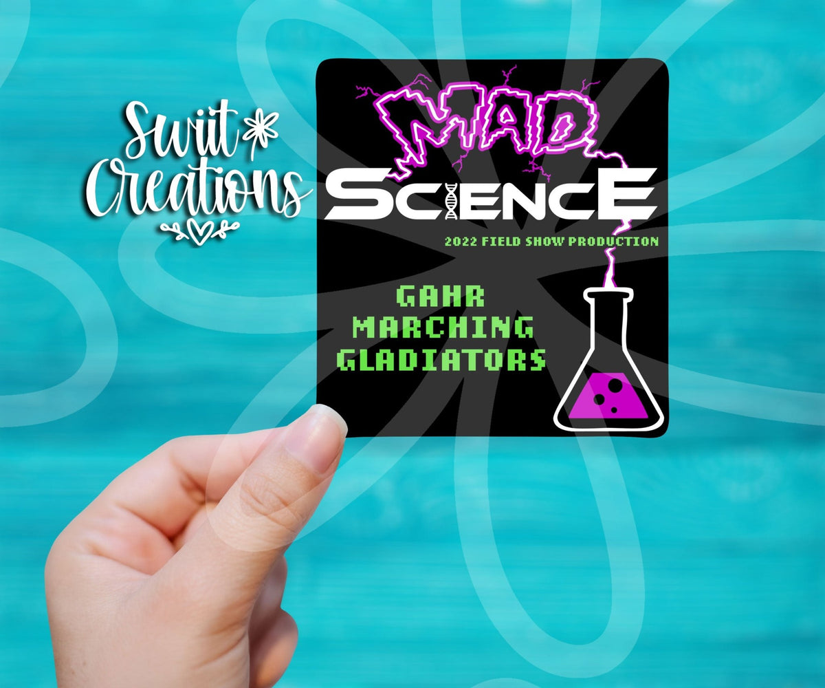 Hand holding a Gahr Mad Science 2022 sticker on a teal background